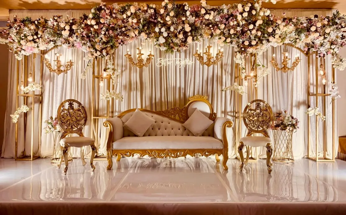 Gold and ivory wedding stage with floral canopy