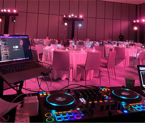 DJ controller at a gala dinner with pink lighting
